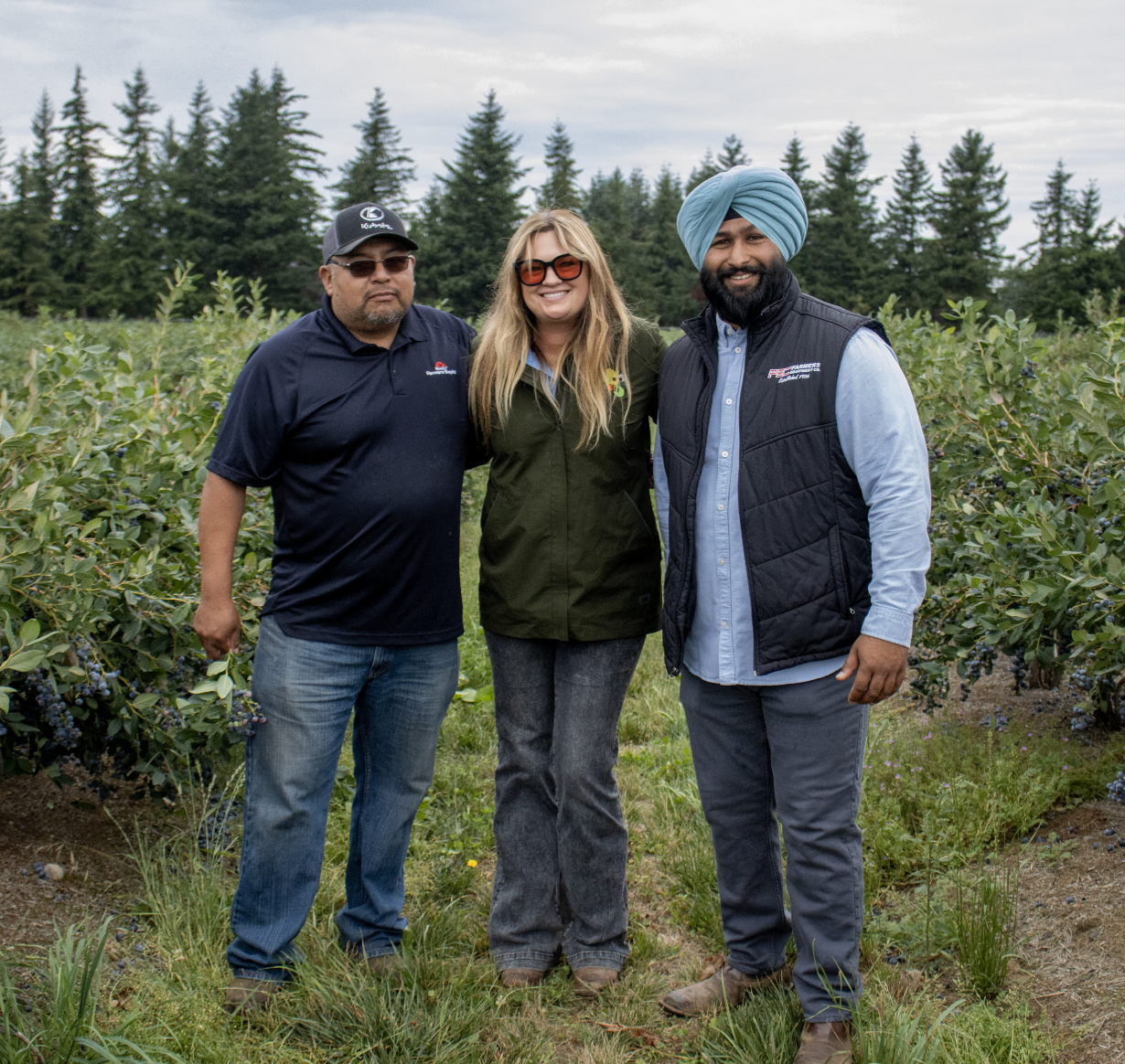 Jose, Jiwan, and Nichole standing together in a berry field in Washington. Jose, Jiwan, and Nichole standing together in a berry field in Washington.